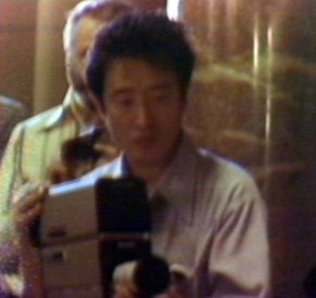 Nam Jun Paik at the camera during a performance of the TV Cello. (video still from photograph: Stephen Jones)